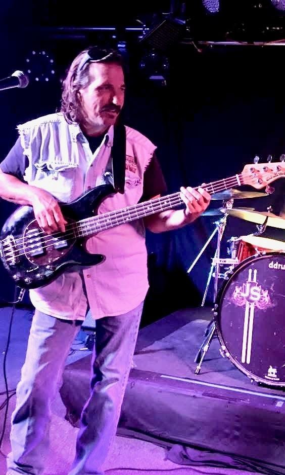 Lindsey White on bass under purple stage lights