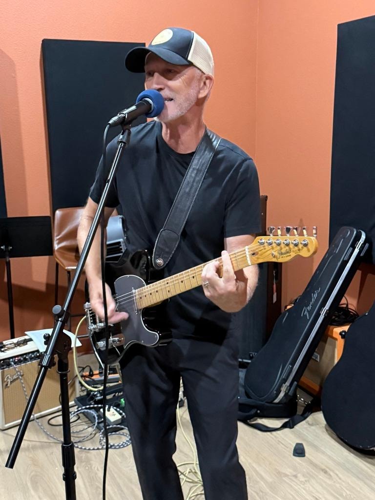 Michael Allen Miller singing and playing guitar in studio